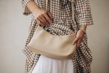 Model, woman, hands close-up with a handbag in a dress, on a white background