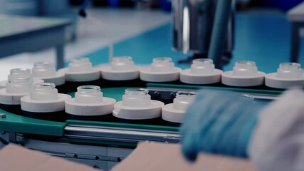Filling bottles with cosmetic cream in a factory, assembly line work