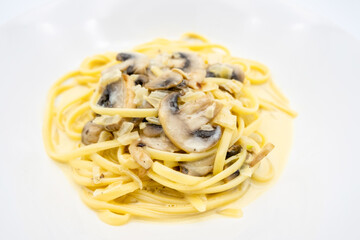 A creamy mushroom pasta dish featuring spaghetti twirled elegantly on a plate, showcasing rich flavors and a delightful presentation.
