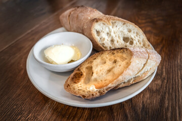 Homemade sourdough bread with cream cheese on the white plate, on the wooden table