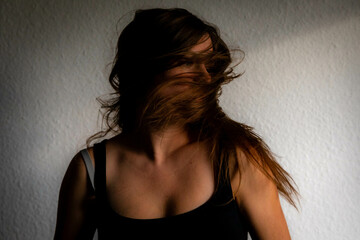 Female Caucasian shaking her long brown hair and head