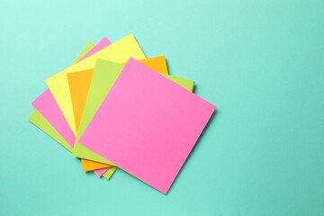 Top view of stack of colorful sticky notes on blue background