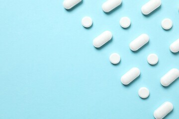 White medicine pills on color background