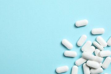 White medicine pills on color background