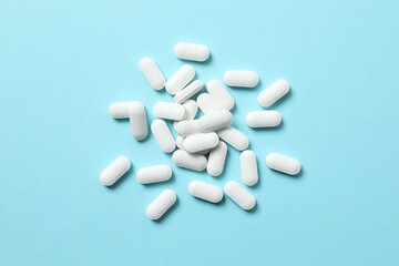 White medicine pills on color background