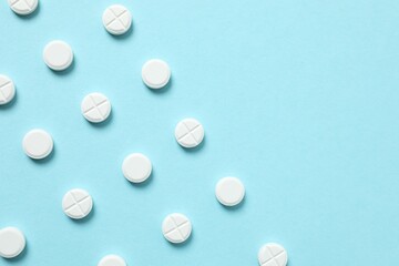 White medicine pills on color background