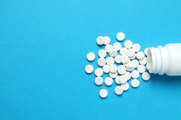 White medicine pills on color background