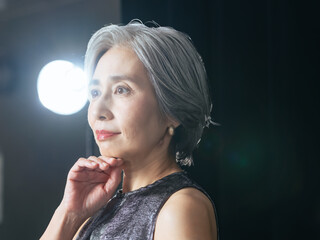 Obraz premium シニア, 女性, スキンケア, 美容, スポットライト, ステージ, 女優, 高齢者, アクティブ, コスメ, 化粧品, ポートレート, タレント, インタビュー, 撮影, 照明, グレイヘア, 白髪, アンチエイジング, エイジングケア, 美人, 美肌, 美白, ホワイトニング, 美顔, ナチュラル, パーティー, スタジオ, しわ, しみ, たるみ, 若々しい, 50代, 60代, セレブ, 