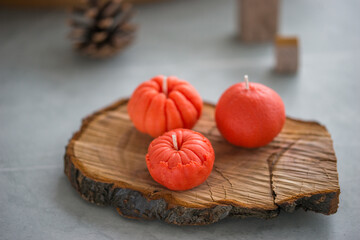 Small bright orange candles in the shape of a tangerine