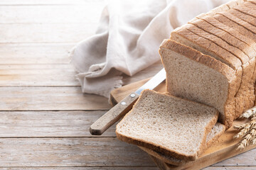 Healthy wholemeal bread slices on rustic wooden table. Copy space