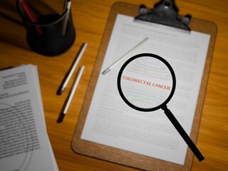 3D rendered "COLORECTAL CANCER" in bold red text under a magnifying glass on a clipboard paper, 3D rendered on a table.