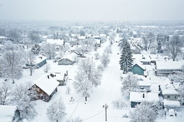 Scenic aerial view of a snowy town with buildings and streets visible below
