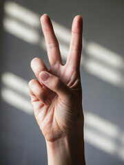 Peace Sign Pose: An extreme close-up shot of a single hand holding up a peace sign, with two fingers extended gracefully