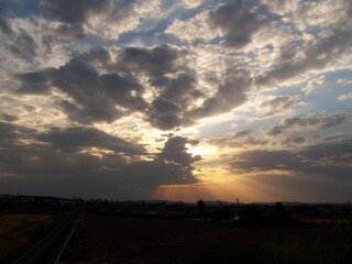 Countryside landscape with a dramatic cloudy sky and sunbeams penetrating through clouds