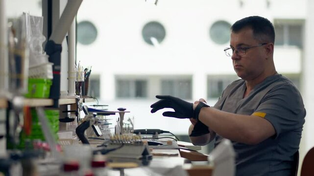 professional laboratory for the production of dental protoses veneers and crowns a specialist adjusts a crown to the shape of a person's jaw gums professional equipment
