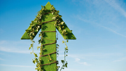 Obraz premium A green upward arrow pointing towards the sky, symbolizing growth and progress, set against a clean blue sky background. The scene conveys a sense of optimism and environmental awareness
