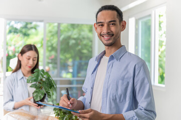 Young Asian couple using order checking list packing tree before send to customer after receive product online purchasing order. Young entrepreneurs e-commerce business concept.