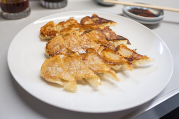 Japanese dumpling or Gyoza on the white plate with soy sauce