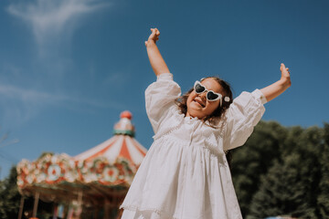 Happy little girl at an amusement park in summer, space for text