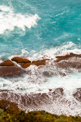 Drone image of water smashing against rocks