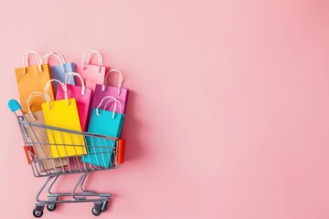 Colorful Shopping Bags in a Miniature Shopping Cart on Pink Background