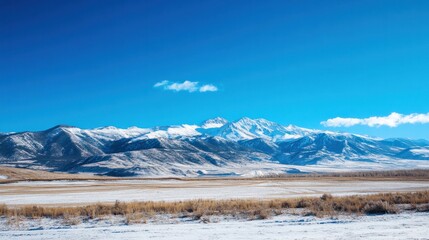 Snow-capped mountains under a clear blue sky, perfect for winter travel background themes