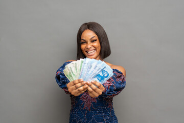pretty excited young african woman flaunting some cash