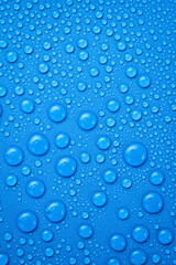 Drops of spring water on a blue textured background.