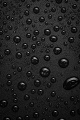 Macro photo of water drops on a black background. Top view. Vertical photo. Free space.