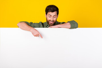 Photo of nice young man point finger empty space wear shirt isolated on yellow color background