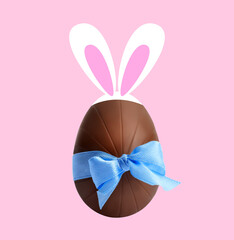Happy Easter. Chocolate egg with bunny ears and light blue bow on pink background