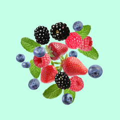 Mix of fresh berries in air on turquoise background