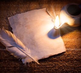Old paper and feather lit by a lamp