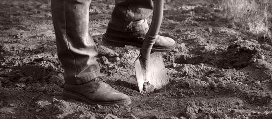 Obraz premium Man's feet with a shovel
