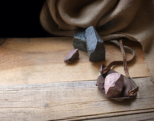 An antique leather sling lies on wooden desk