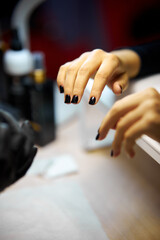 Women's manicure. Female hand undergoing a manicure procedure. The master does a women's manicure. A manicurist files a women's nails in a salon. Hygiene and hand care for woman. manicure design.