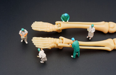 Miniature Surgeons with Human Skeleton Feet on Black