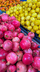  grocery store filled with a variety of fruits . grenades lemons and persimmons. Assortment of...