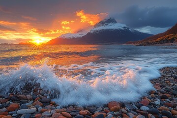 Sunset Over a Rocky Beach with a Snowy Mountain Range in the Distance