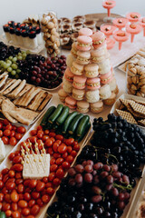 A sweet table with fruit, cookies and pasta stacked in a high pyramid.
