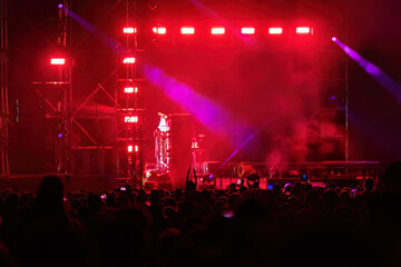 Stage lights as defocus bokeh background at a music concert and party people in a crowd