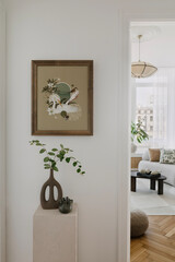 Minimalist nook with a touch of green, framed artwork, and organic shapes. A serene blend of natural and modern elements.