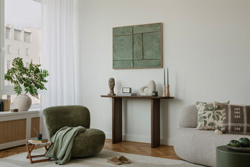 Contemporary space featuring a soft, neutral palette with green accents, a unique armchair, and...