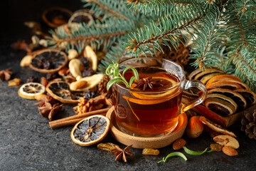 Tea with spices and dry fruits on a kitchen table.