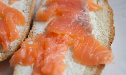 Sandwiches with cream cheese and sliced ​​salmon on a plate. Sliced ​​pieces of salmon on bread with cream
