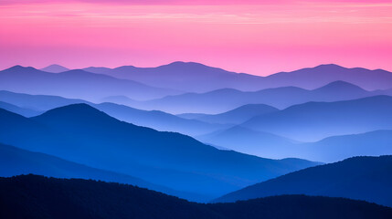 Obraz premium Silhouettes of mountain ranges against a pink and blue sky at sunrise.
