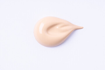 A smear of foundation cream or concealer on white background, macro. Texture of cosmetic liquid foundation or beige cream smudge, smear, stroke..