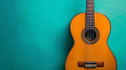 Obraz premium A close-up of an acoustic guitar against a teal background.