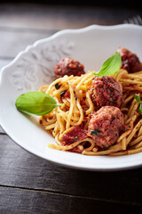 Spaghetti Pasta with Meatballs and fresh Basil on dark background.