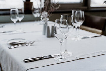 The restaurant features a stylish and contemporary interior complete with elegant table settings and vibrant plants.